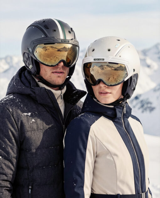 Zwei Skifahrer tragen Casco SP-6 Skihelme mit Visier in verschneiter Berglandschaft.
